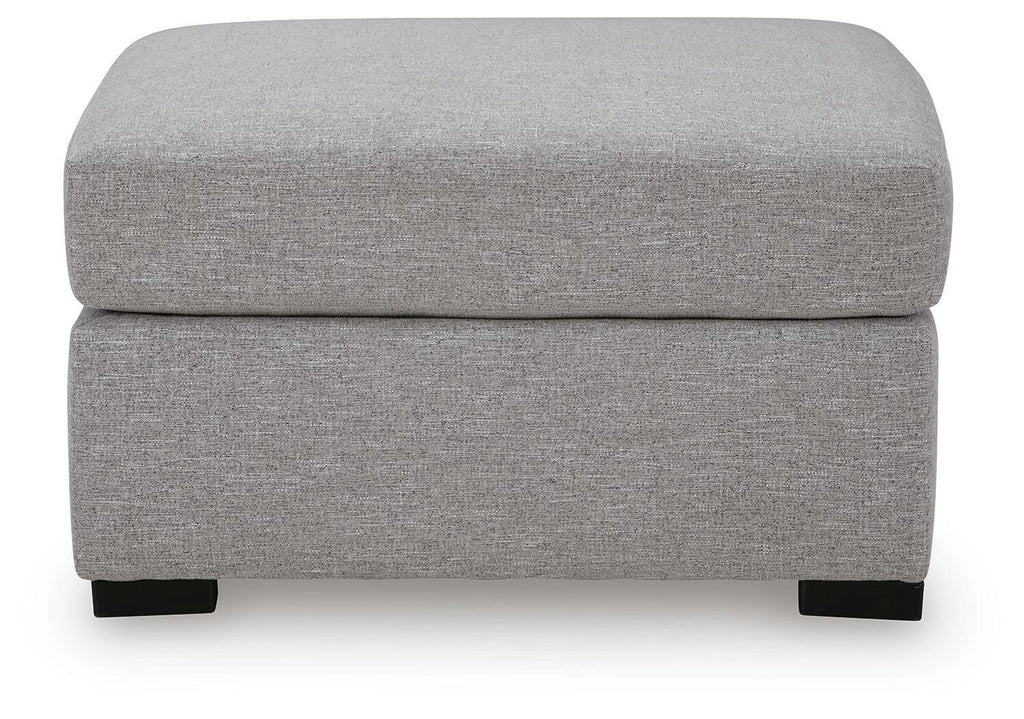 Pewter gray upholstered ottoman with cushioned lid and black feet, front view