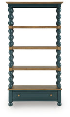 Blue bookcase with brown open shelves and lower drawer, turned column sides.