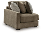 Upholstered corner chair with rolled arms, taupe fabric and four decorative pillows