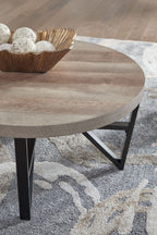 Round table top with grayish-brown wood grain and black cross-brace legs