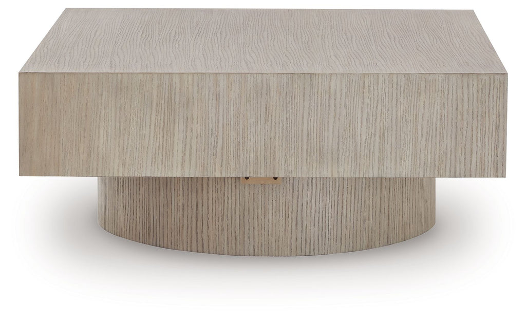 Light brown square table with flat top and rounded center pedestal