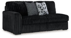 Corduroy sectional sofa in dark onyx black with ribbed arms and two throw pillows