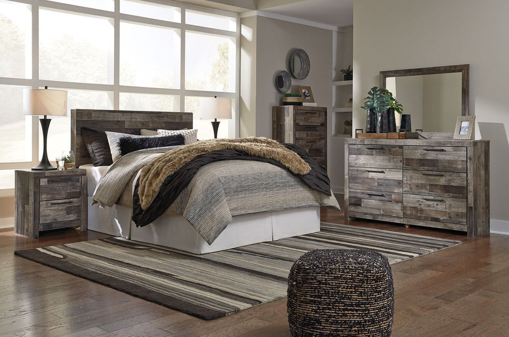 Panel headboard bed frame in gray-wash wood with layered bedding and side tables