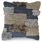 Patchwork throw pillow with dark blue, tan, and gray panels plus chunky fringe