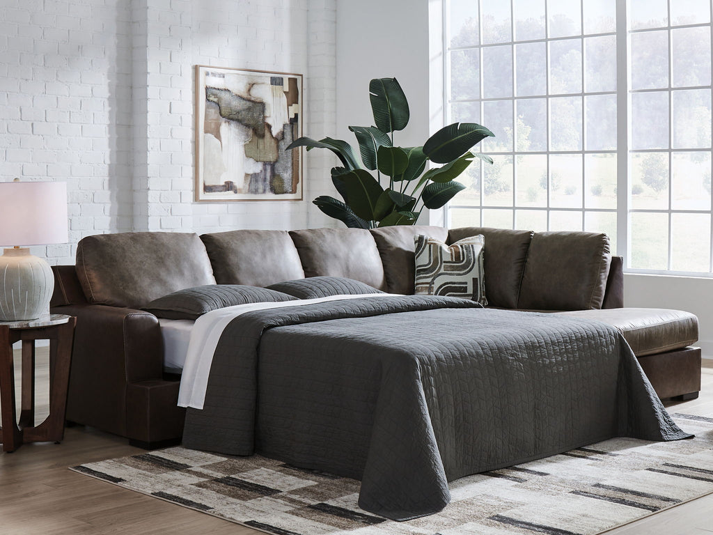 Dark fossil sectional sofa with chaise, gray pillows, and a draped throw blanket