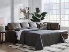Dark fossil sectional sofa with chaise, gray pillows, and a draped throw blanket