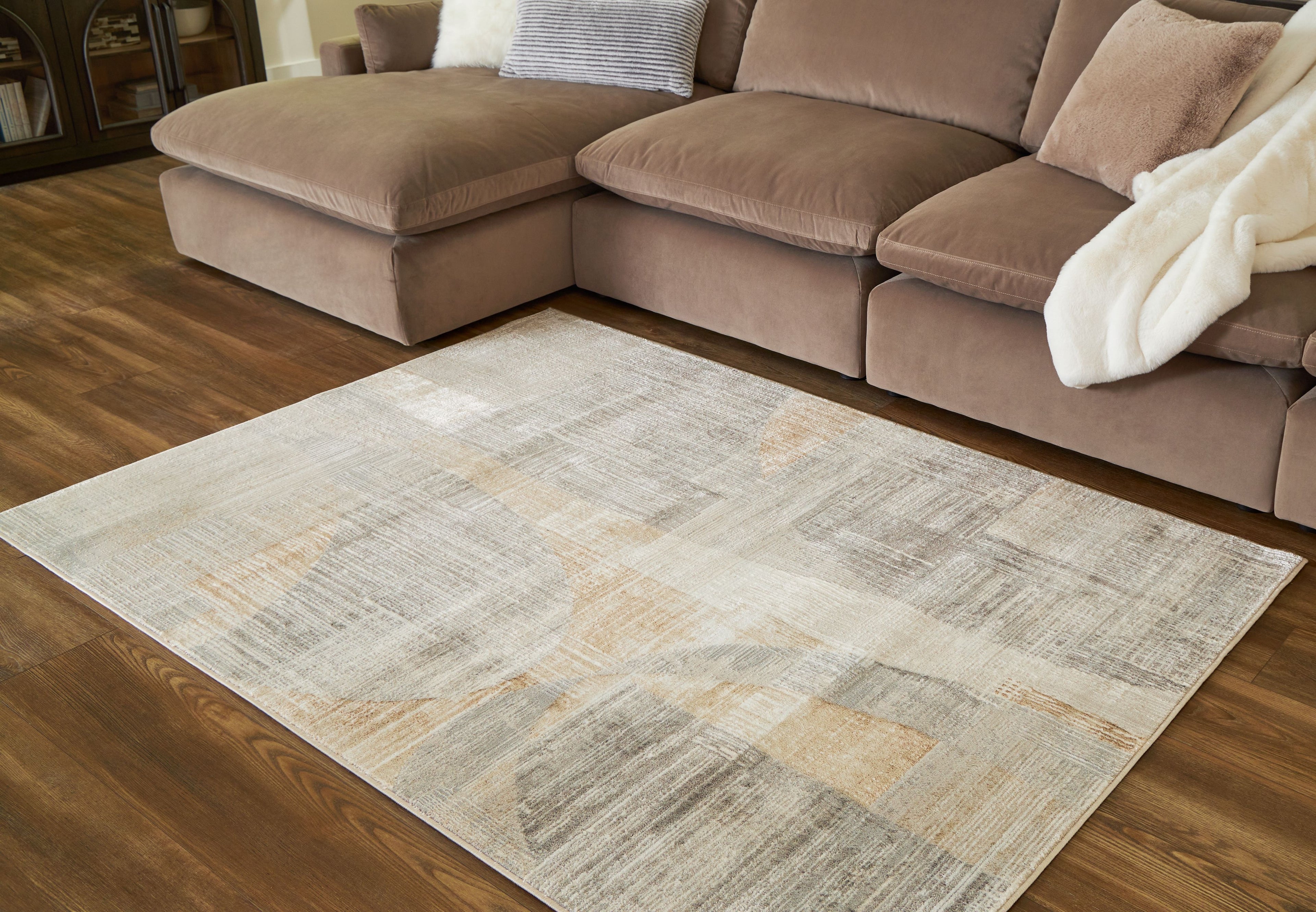 Beige abstract area rug on hardwood floor, rectangular, distressed flat weave