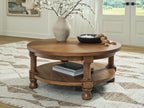 Round light brown wooden coffee table with two-tier design and turned legs