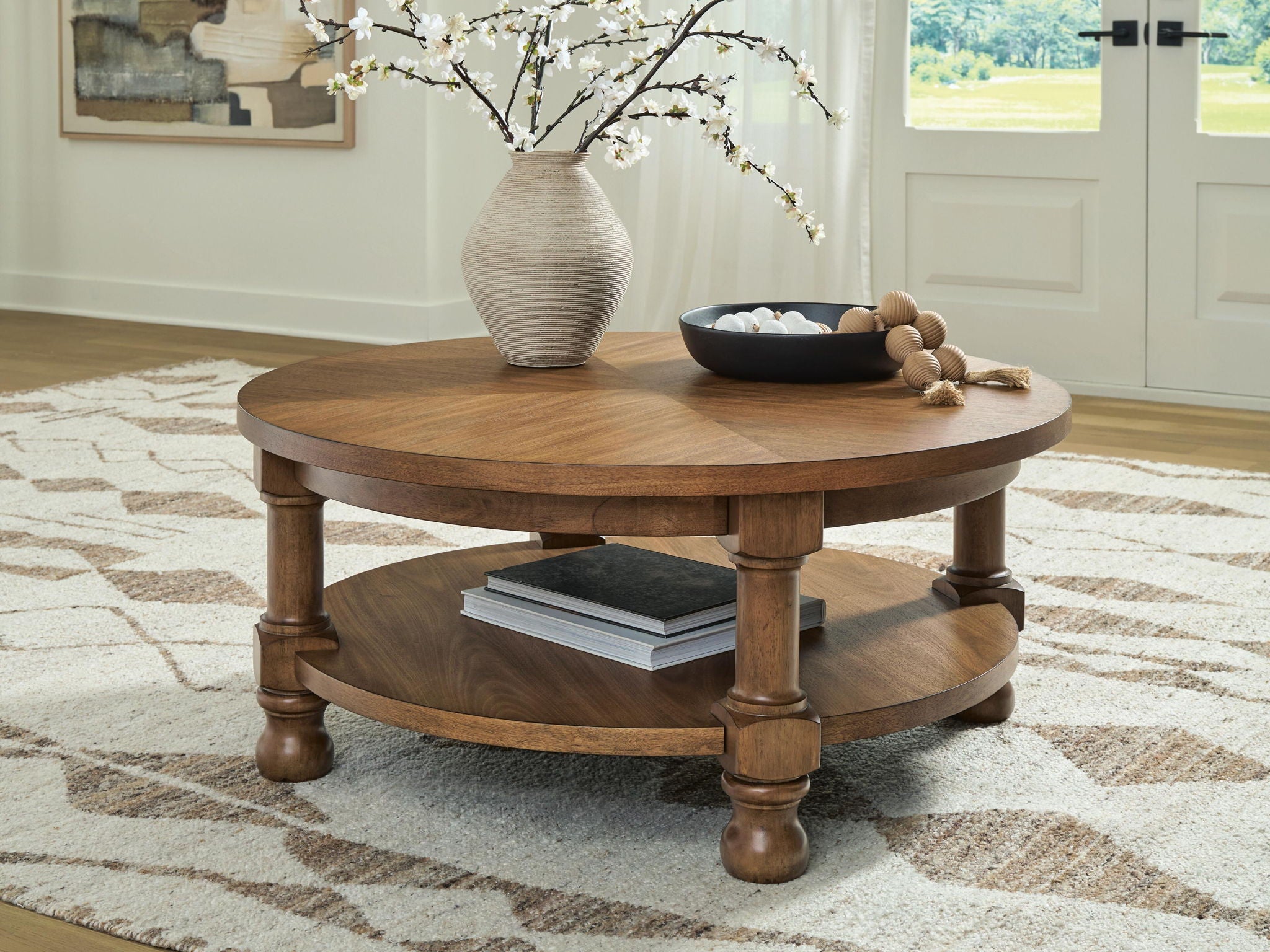 Round light brown wooden coffee table with two-tier design and turned legs