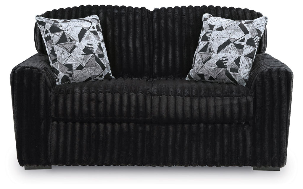 Black corduroy loveseat with two black-and-white geometric throw pillows