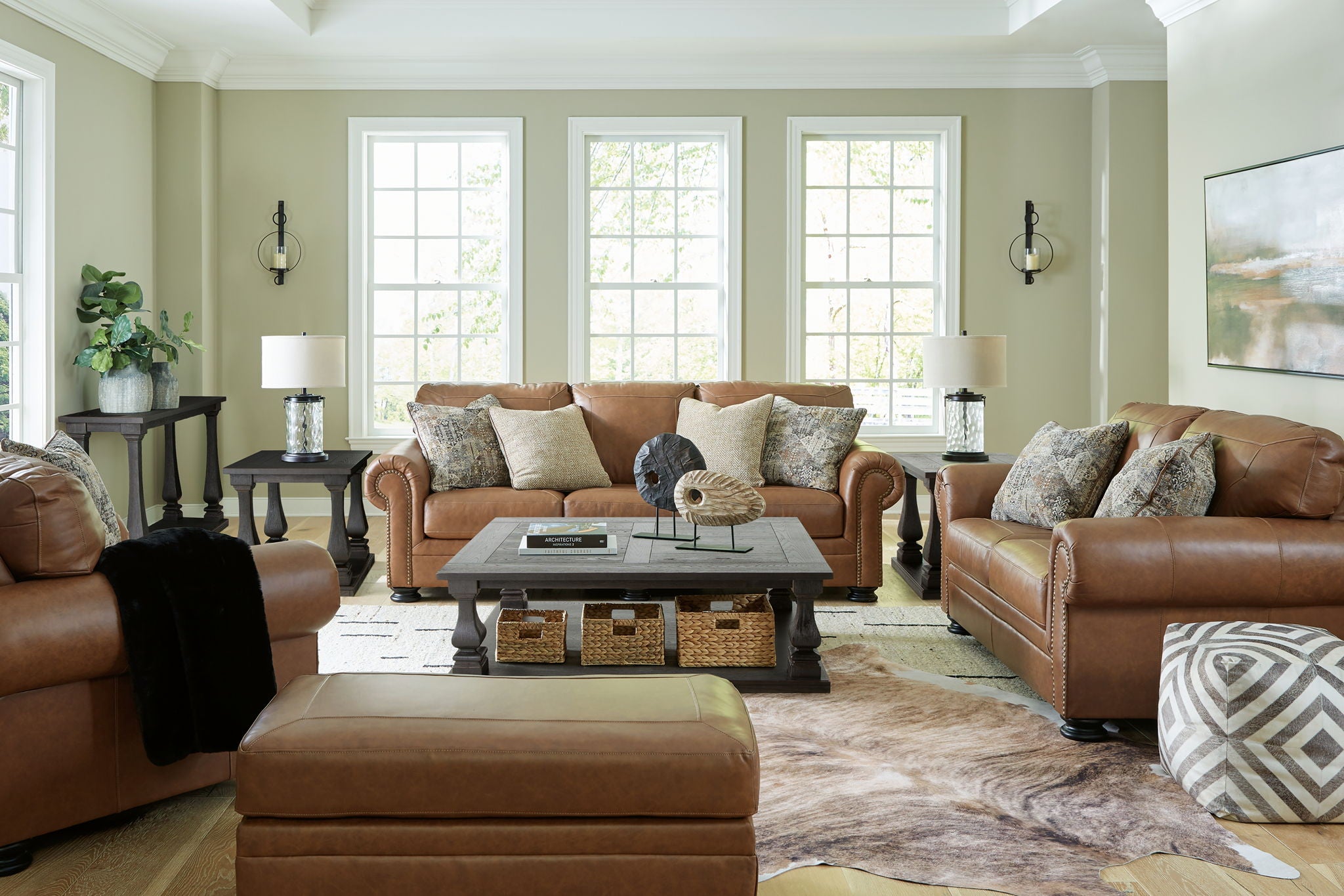 Brown living room seating set with sofa, armchairs, ottoman, and patterned throw pillows