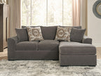 Gray sectional sofa with chaise extension and patterned throw pillows on the backrest