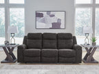Charcoal reclining sofa with three seat cushions and straight back panels