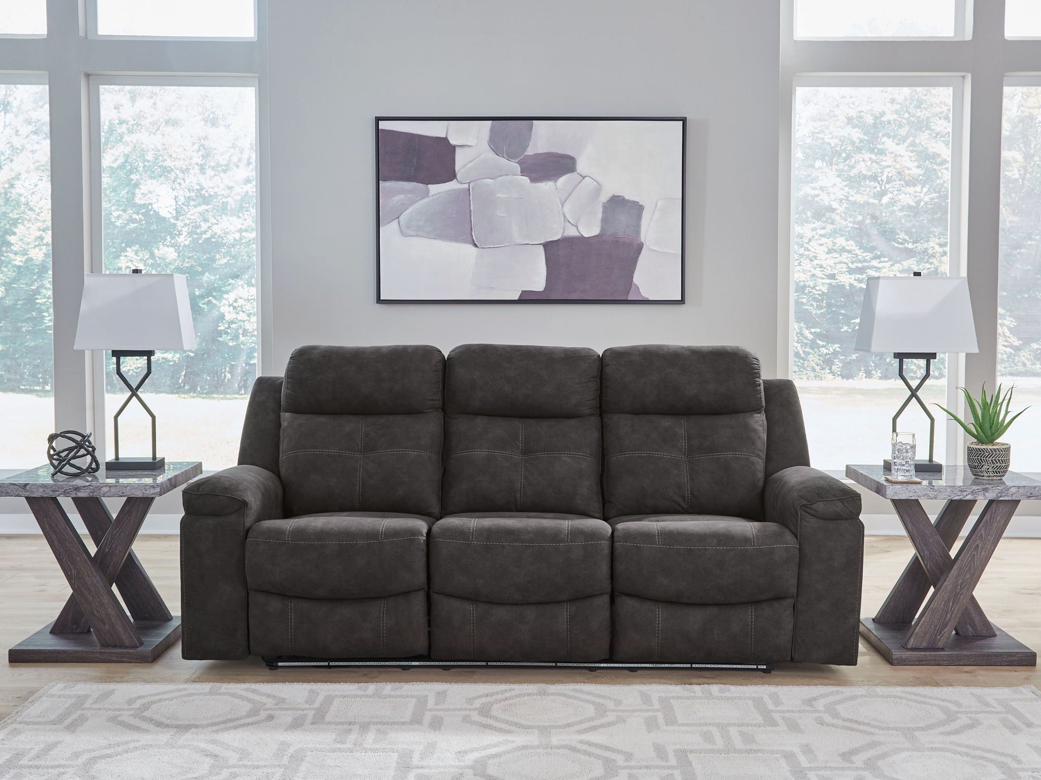 Charcoal reclining sofa with three seat cushions and straight back panels