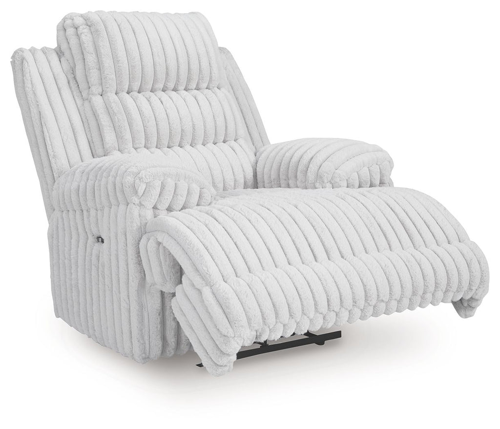 Light gray zero wall recliner with extended footrest, padded armrests, and channel tufting