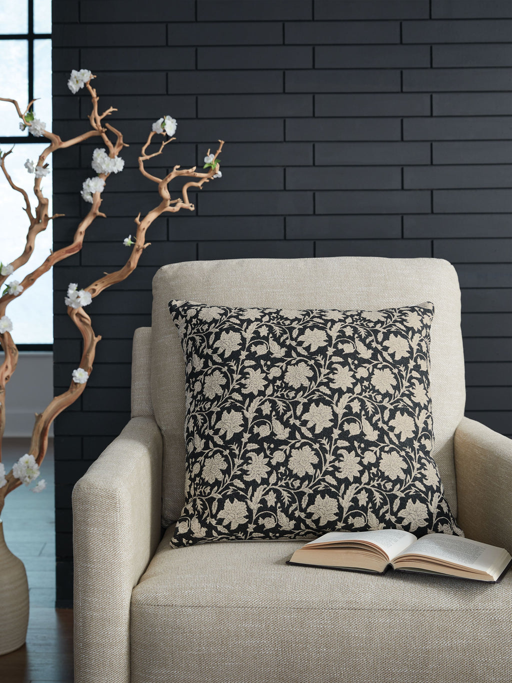 Black and beige floral decorative pillow on a light fabric sofa