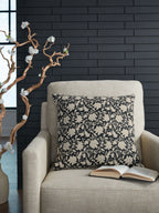 Black and beige floral decorative pillow on a light fabric sofa