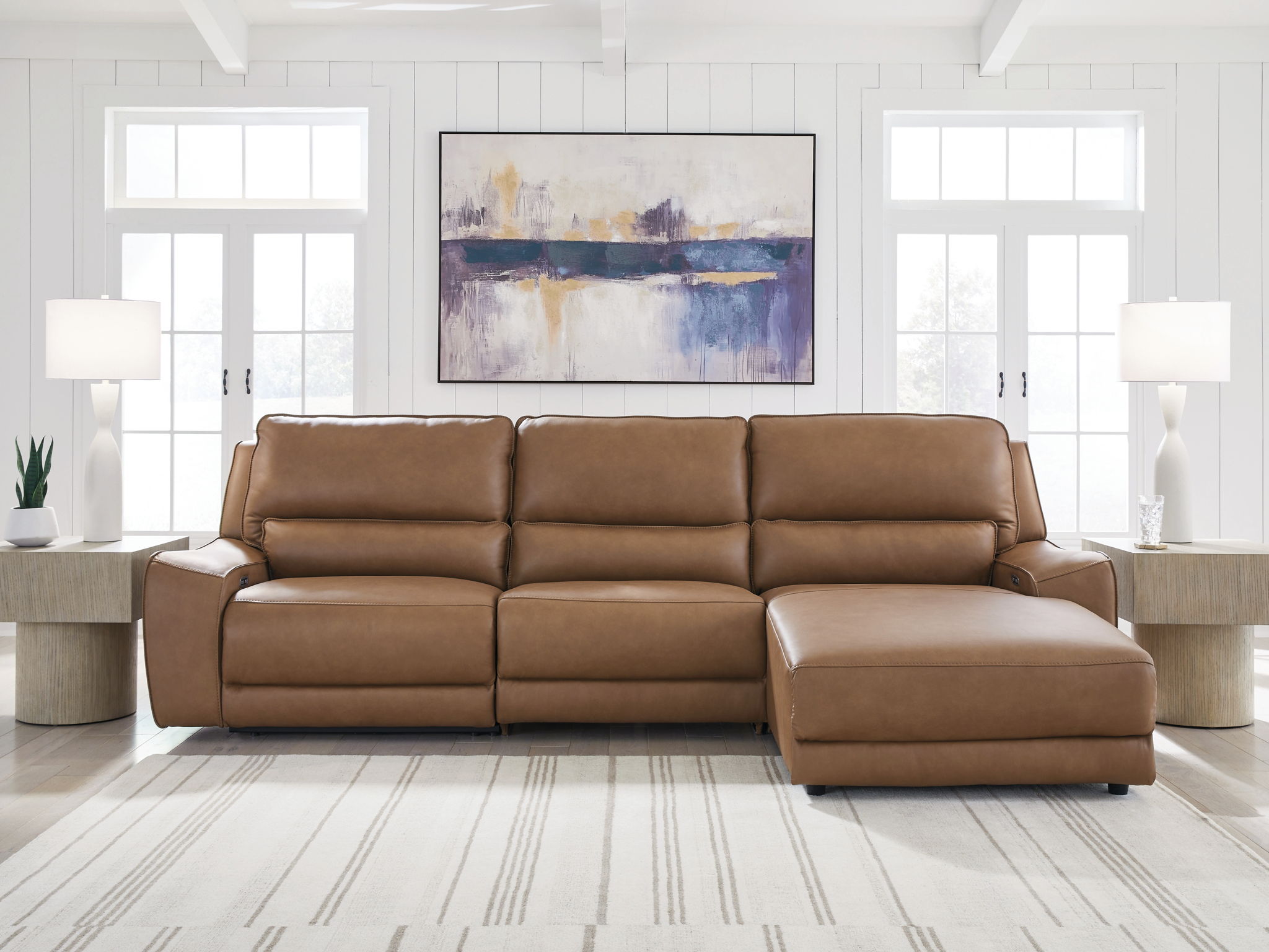Caramel power reclining sectional sofa with chaise extension and wide back cushions