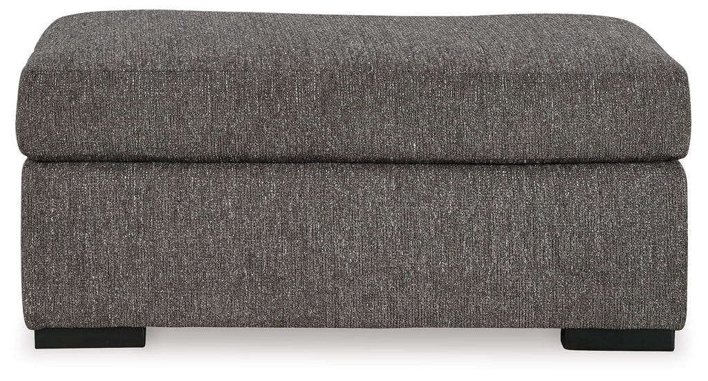 Pewter fabric ottoman with thick, rounded back panel and low black legs