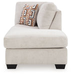 Stone fabric corner chaise with curved arm and geometric throw pillow, black legs