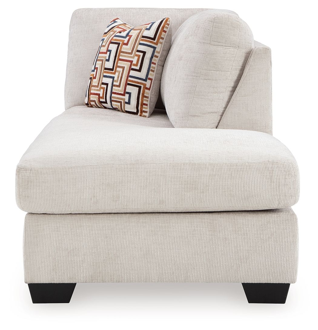 Stone fabric corner chaise with curved arm and geometric throw pillow, black legs