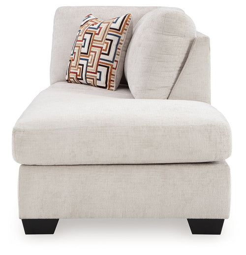 Stone fabric corner chaise with curved arm and geometric throw pillow, black legs