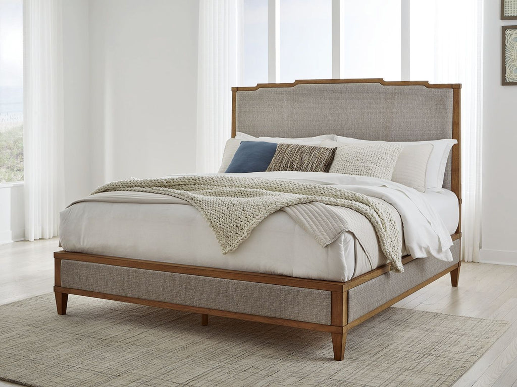 Upholstered panel bed with light gray base, wooden frame, white bedding and folded blanket