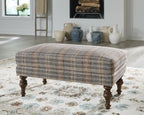 Multi plaid accent ottoman with rounded arms and dark turned wooden legs