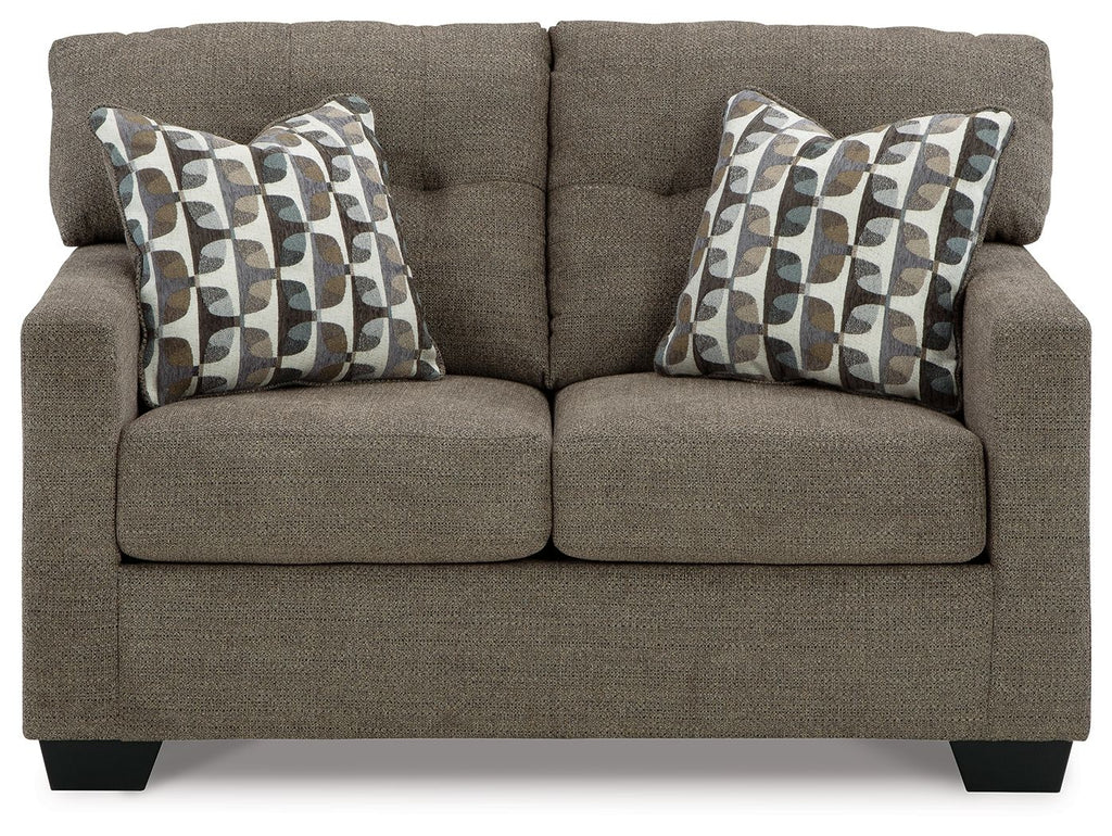 Dark brown loveseat with two patterned throw pillows and thick back cushions