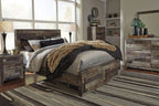 Dark wood panel bed frame with tan faux-fur throw and gray bedding on striped rug