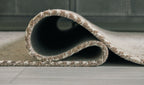 Rolled beige rug showing dark backing and textured weave