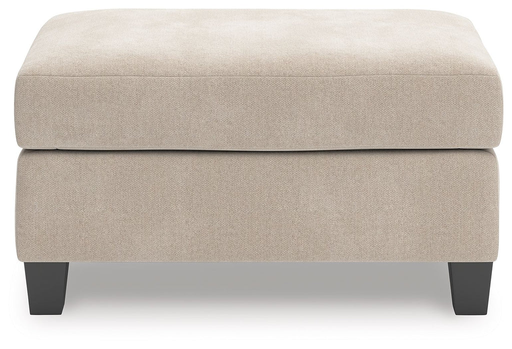 Taupe upholstered ottoman with wide seat cushion and dark tapered legs