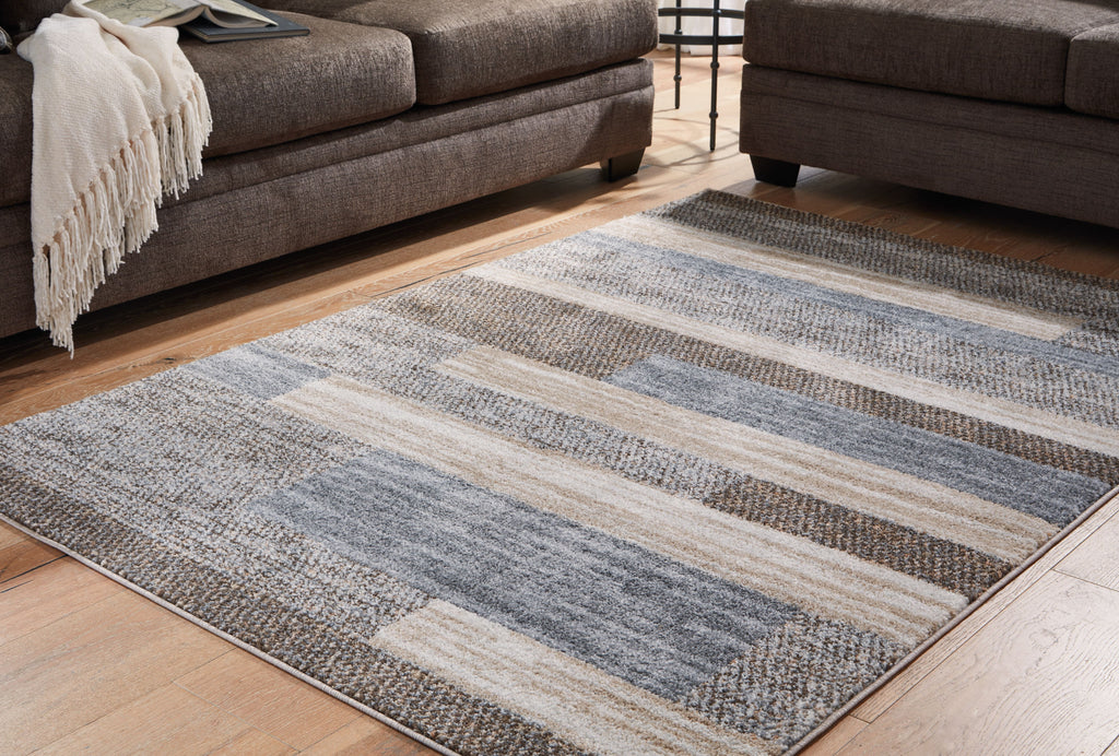 Gray rug with striped blocks and low-cut texture on display