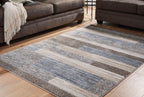Gray rug with striped blocks and low-cut texture on display