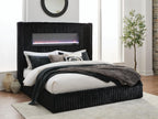 Black upholstered bed with ribbed headboard, fireplace screen, and neatly styled bedding