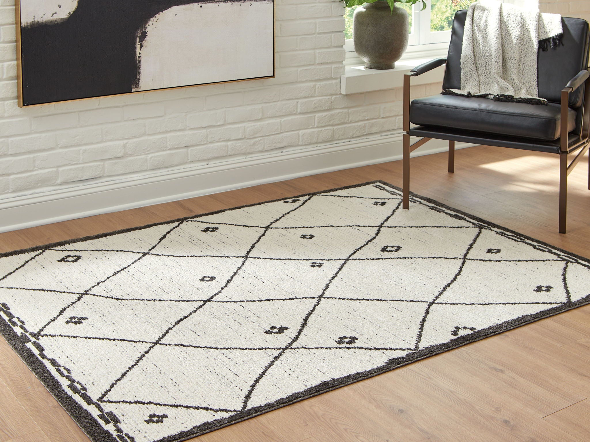 Beige and black geometric area rug with arcing lines and small motif accents
