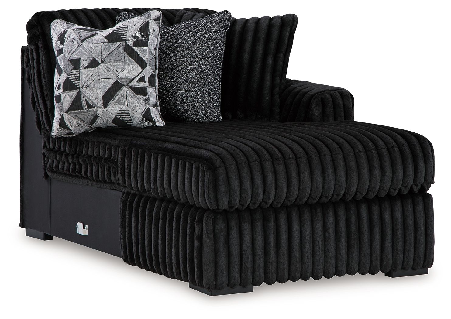 Black ribbed corner chaise with tufted arms and geometric patterned throw pillow