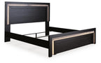 Black panel bed with raised frame base and decorative gold-tone trim along edges