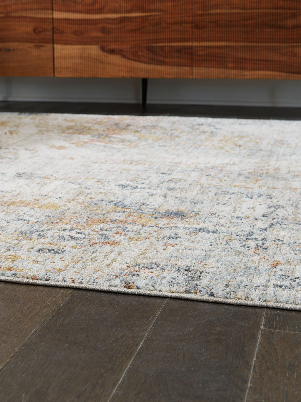 Distressed area rug corner, flat pile; light gray/blue with orange speckled pattern