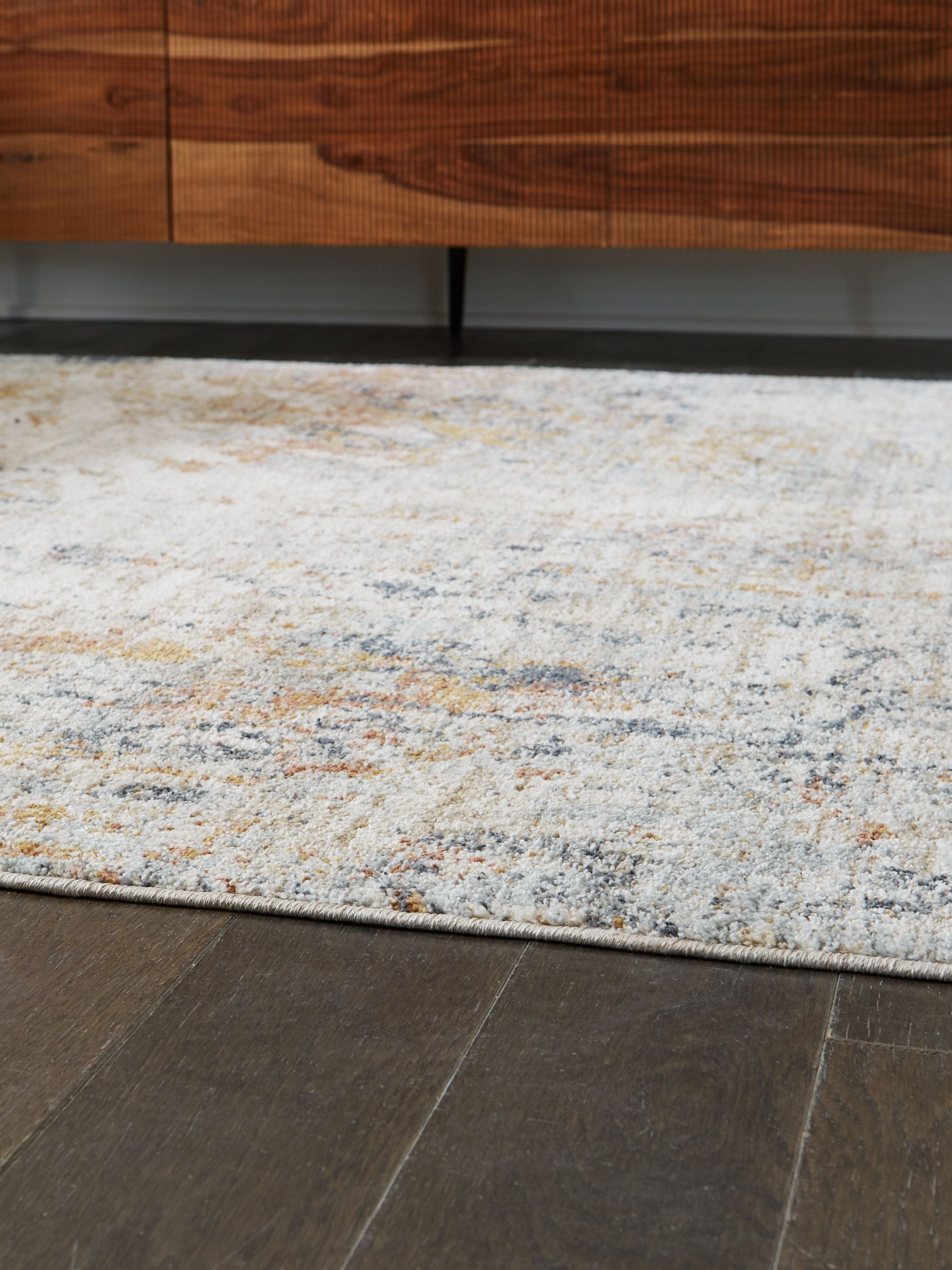 Distressed area rug corner, flat pile; light gray/blue with orange speckled pattern