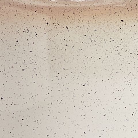 Close-up of speckled cream lamp ceramic surface with fine dark dots