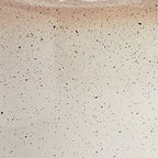 Close-up of speckled cream lamp ceramic surface with fine dark dots