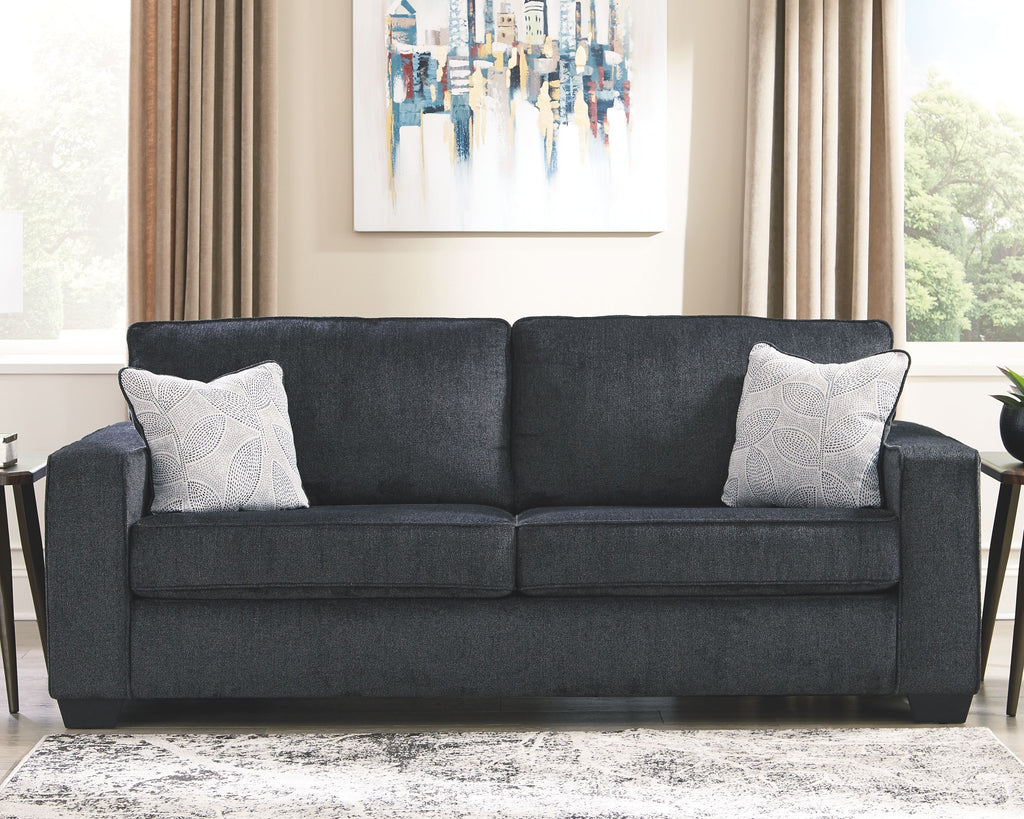Slate sleeper sofa styled in a living room with two patterned throw pillows