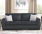 Slate sleeper sofa styled in a living room with two patterned throw pillows