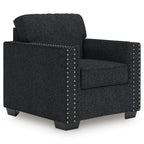 Dark charcoal upholstered armchair with padded back, wide arms, and silver nailhead trim.