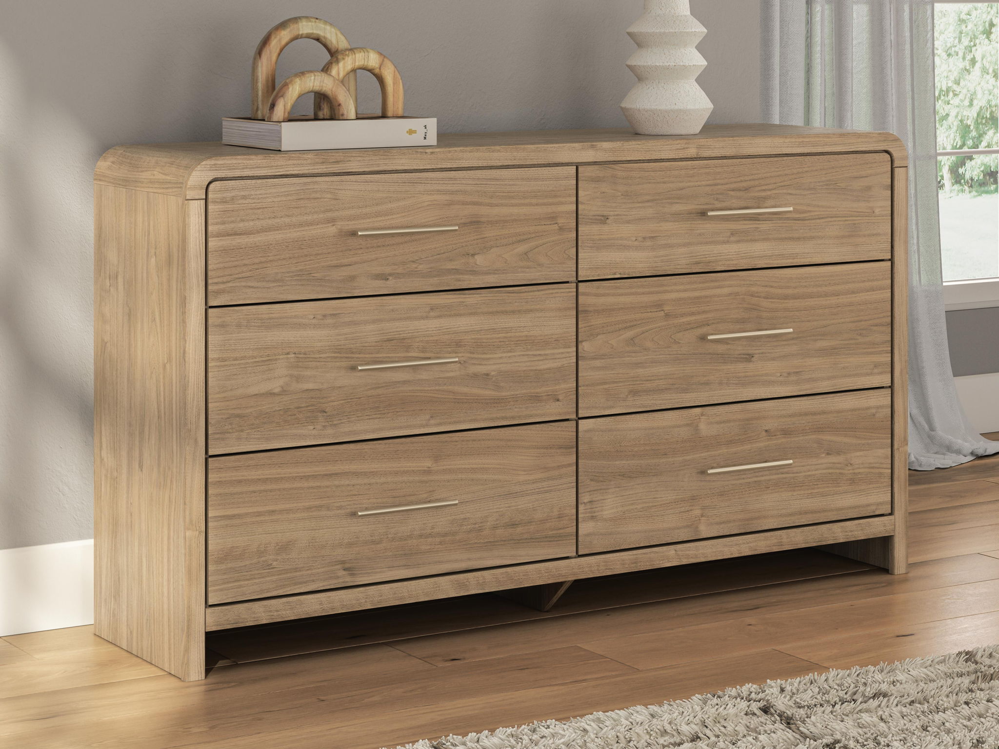 Light brown six-drawer dresser with wide drawer fronts and brushed metal bar pulls