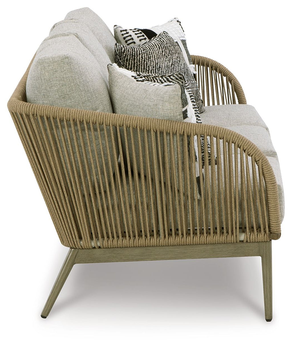 Beige woven sofa with light gray cushions and assorted patterned accent pillows