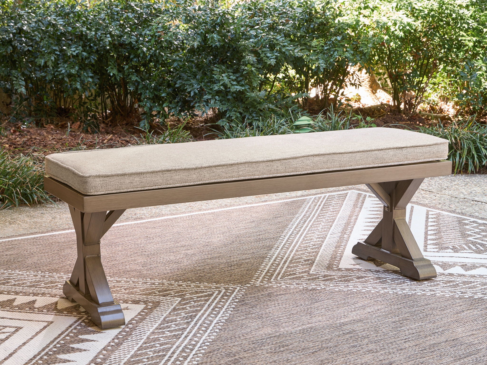 Cushioned outdoor bench with beige top and dark wood base, long bench style