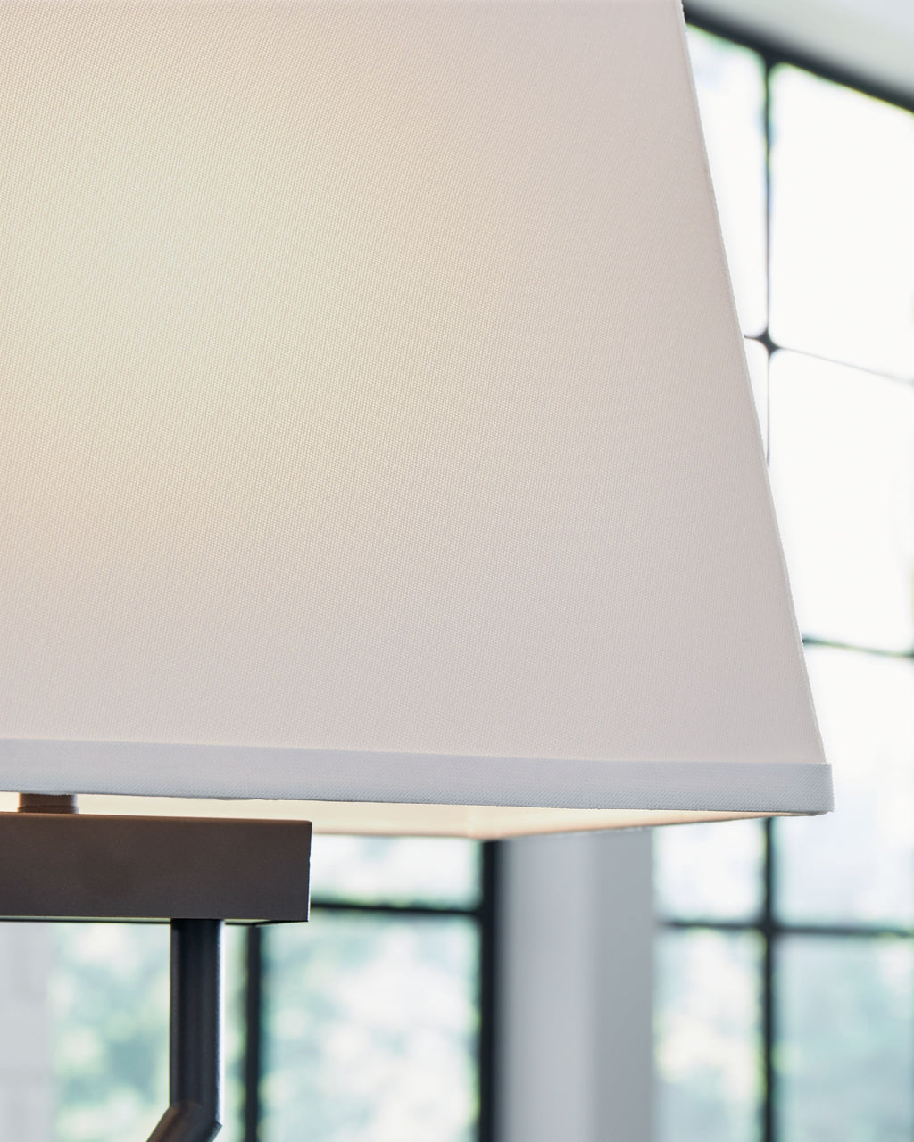 Black metal table lamp with white fabric shade and brushed base edge