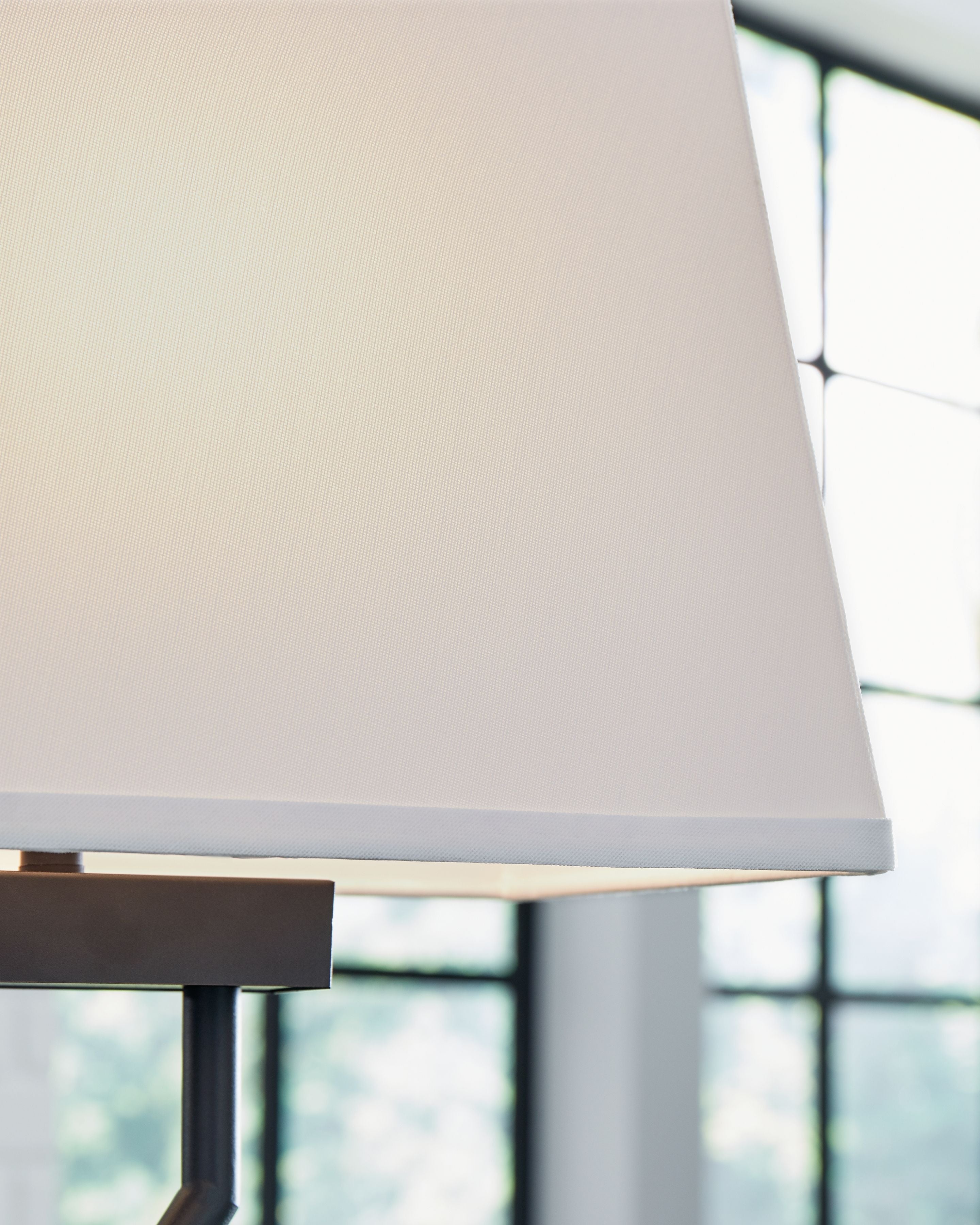 Black metal table lamp with white fabric shade and brushed base edge
